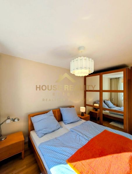 Bedroom in a 4-room apartment with a double bed, wardrobe, and lamp, flooring with a wooden decor.