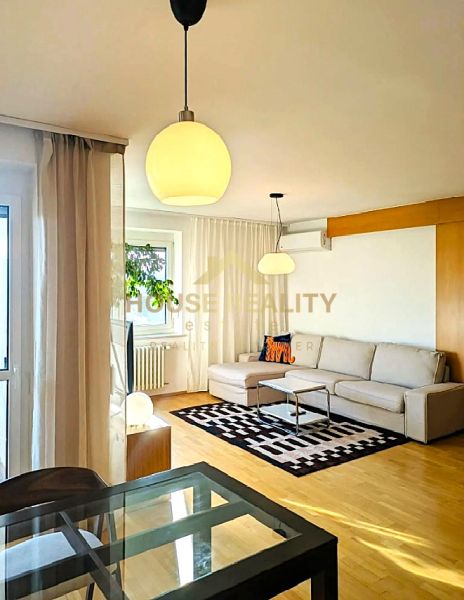 Living room in a 4-room apartment with a wooden decor floor and comfortable seating.