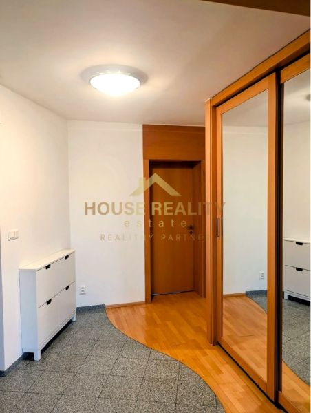 Entrance hall with a mirrored wardrobe and a floor with a wood decor in a 4-room apartment.