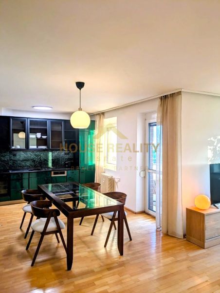Dining area in a 4-room apartment with a wooden decor floor and a glass table.