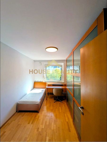 A room in a 4-room apartment with a bed, a table, and a floor with a wooden decor.