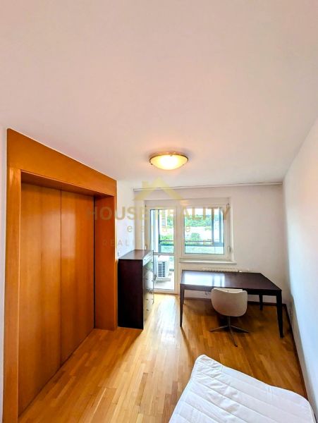 A room with a table, chair, wardrobe, and a floor with wooden decor in a 4-room apartment.