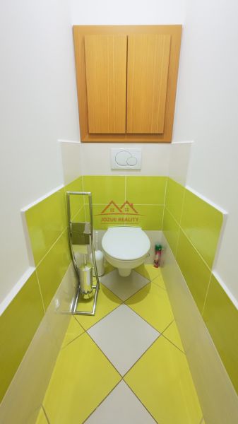 A bathroom with colorful tiles and a wooden cabinet in a two-room apartment.