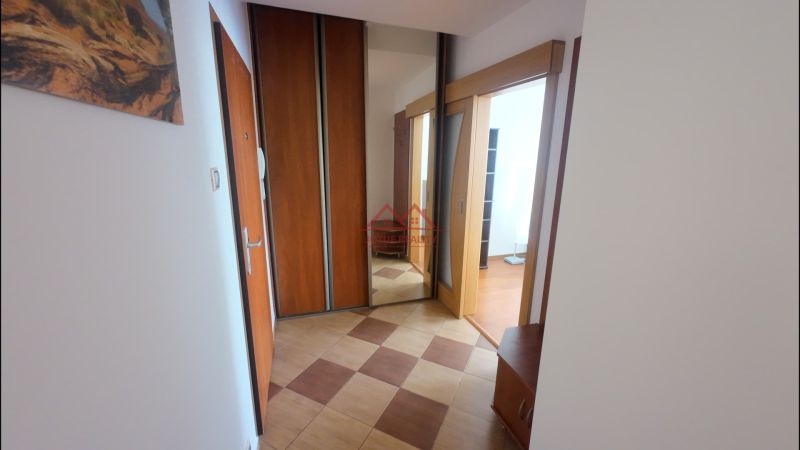 Hallway of a 2-room apartment with tiles, built-in wardrobes, and a mirror.