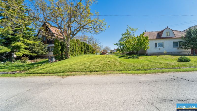 A garden on Nová Street in Viničné surrounded by trees and family houses. Plots - housing.