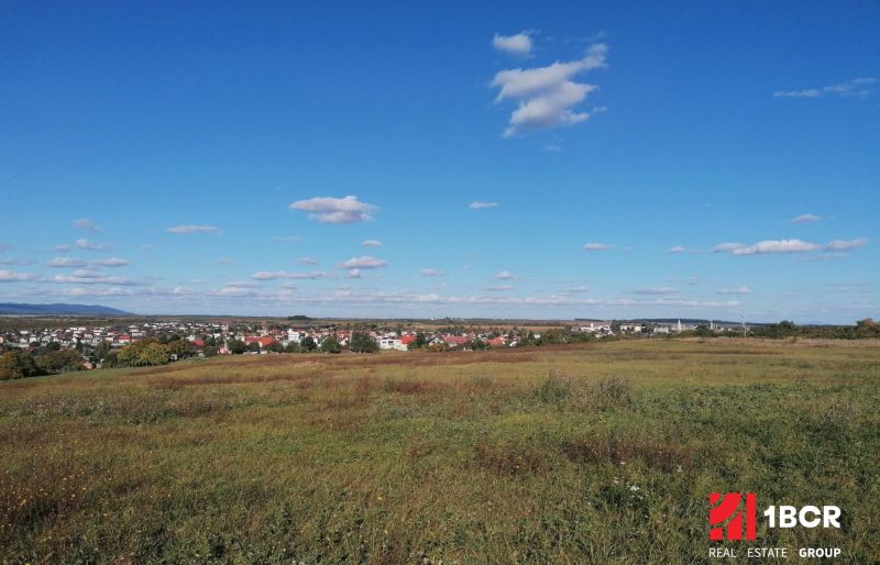 Šenkvice surrounded by agricultural and forest lands under a clear blue sky.