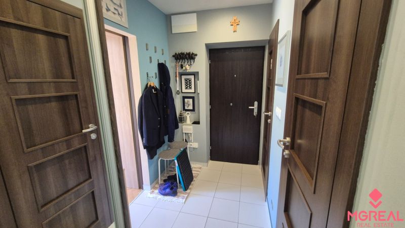 Entrance hall of a 2-room apartment with coat hooks, tiles, and wall decorations.