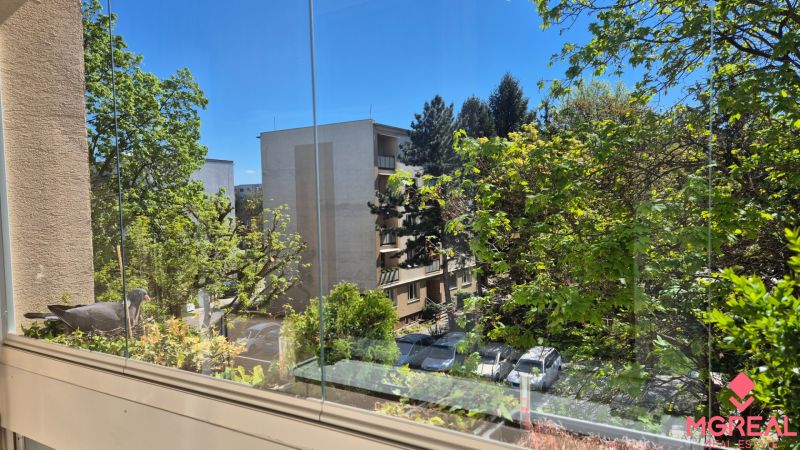 View from the glazed loggia of trees and apartment buildings on Kuzmányho in Topoľčany.