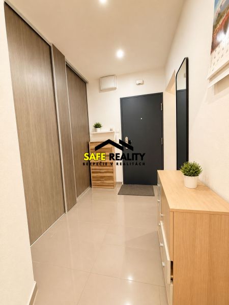 A hallway in a 3-room apartment with a wooden decor floor and simple furnishings.