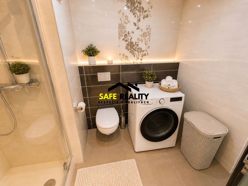 Bathroom in a 3-room apartment with a washing machine, shower corner, and wall decor.
