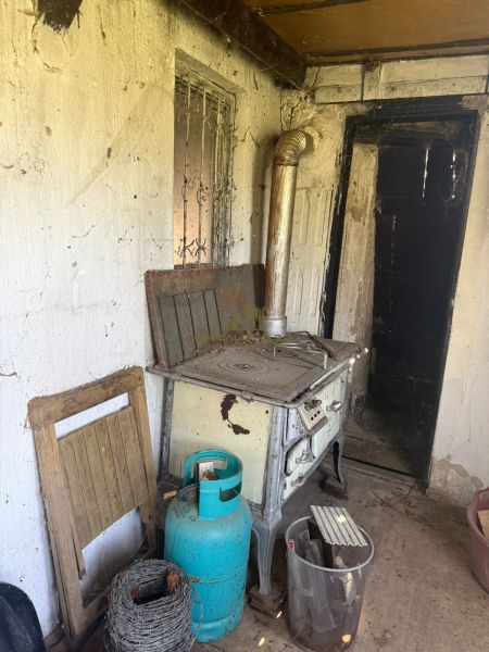 An old stove, a gas cylinder, and cobwebs in the cabin.