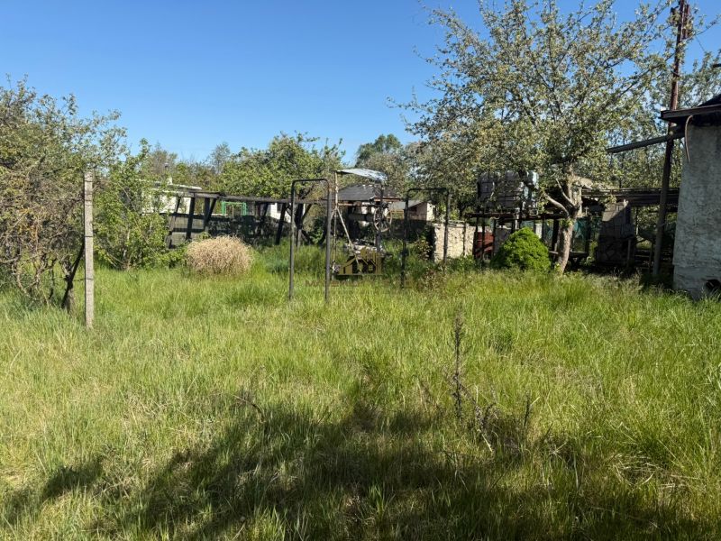 A garden with grass and an old structure near the Cottage in Malacky.