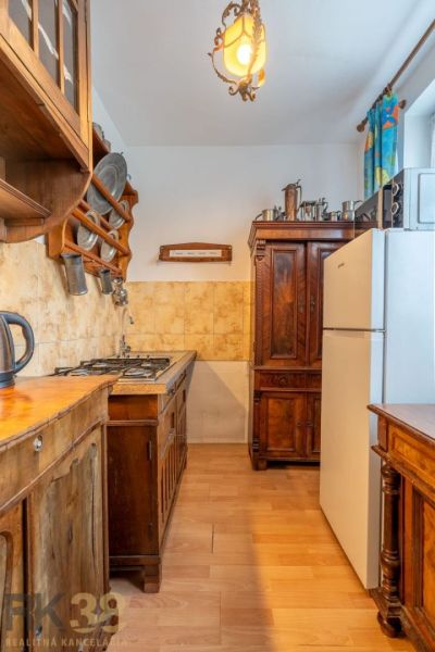 A kitchen in a 4-room apartment with historical furniture and a wooden decor floor.