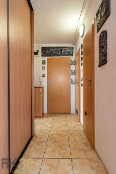 A hallway with a closet and tiles in a 4-room apartment.