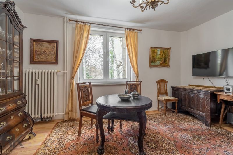Interior of a 4-room apartment with wooden decor, antique furniture, and decorative carpets.