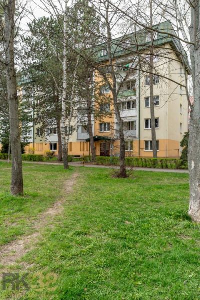 An apartment building on Štúrova Street in Poprad surrounded by trees and a green lawn.