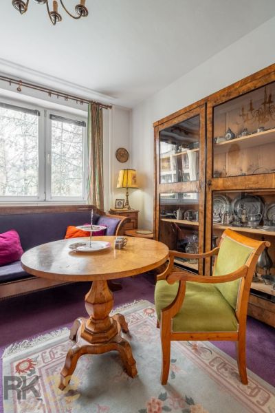 A living room with antique furniture and a wooden decor floor in a 4-room apartment.