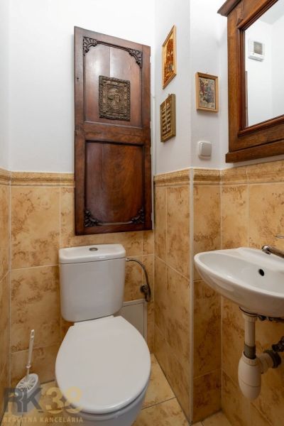 WC with wooden doors and a mirror, ceramic tiles, sink in a 4-room apartment.