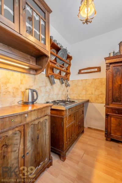 A kitchen with classic wooden furniture and a floor with a wooden decor in a 4-room apartment.