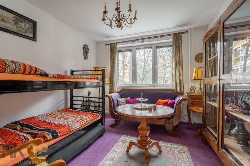 A room in a 4-room apartment with a bunk bed and wooden furniture.