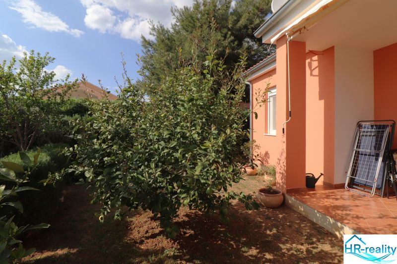 A family house in Vodice with an orange facade and a landscaped garden.