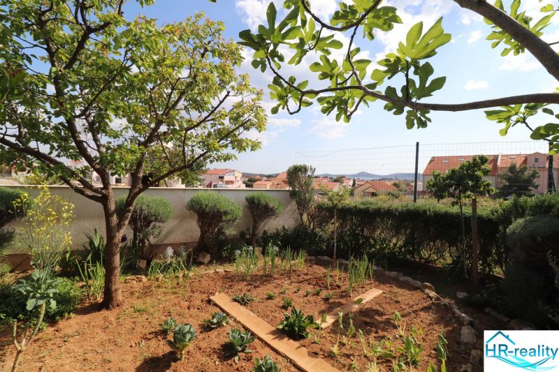 Garden at a family house in Vodice, with a view of the surrounding buildings and the sky.