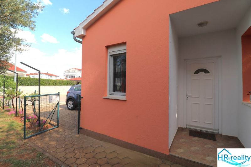 A family house in Vodice with an orange facade and white entrance doors.