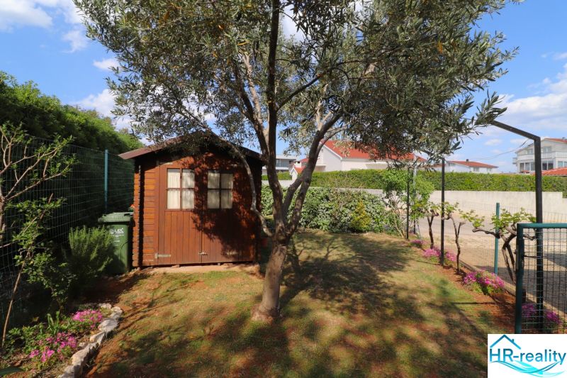A family house in Vodice has a garden with a wooden house and an olive tree.