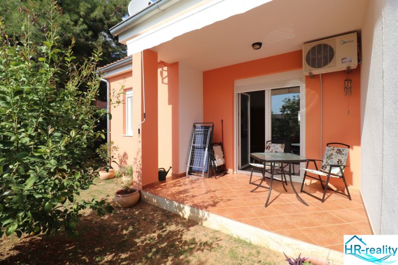 A family house in Vodice with a terrace, garden, and orange facade.
