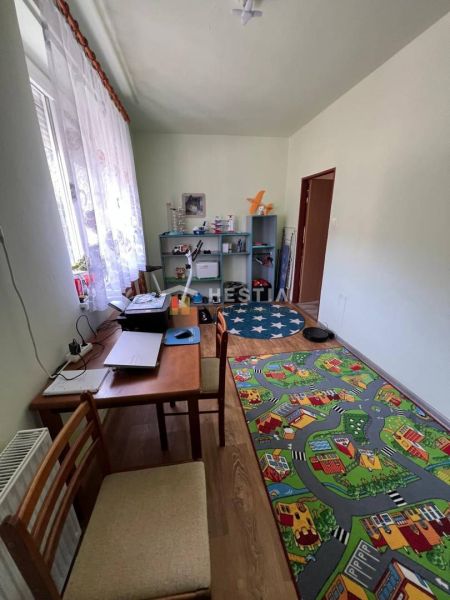 Children's room with a road-shaped carpet, a desk, and a shelving unit.