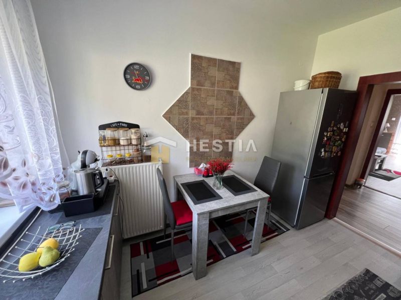 A kitchen with a dining table and a wooden decor floor in a 3-room apartment.