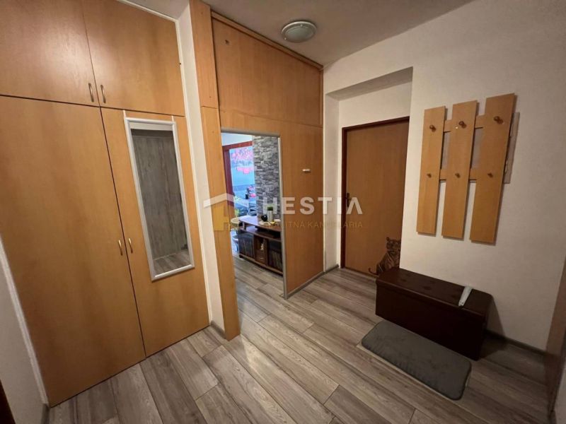 The hallway in a 3-room apartment with wooden decor and built-in wardrobes.