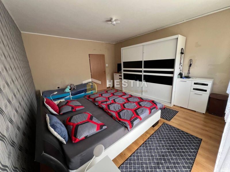 Bedroom in a 3-room apartment with a large wardrobe and a floor with a wooden decor.