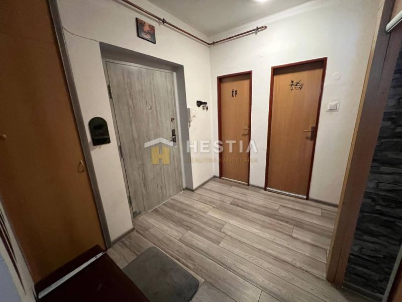 Entrance hall in a 3-room apartment with wood-patterned flooring and two doors.