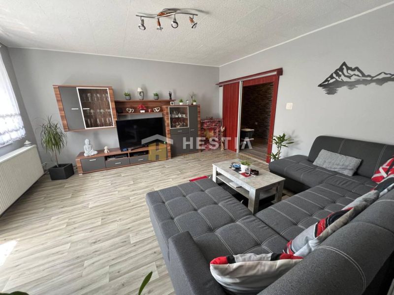 Living room in a 3-room apartment with a couch and a wooden decor floor.