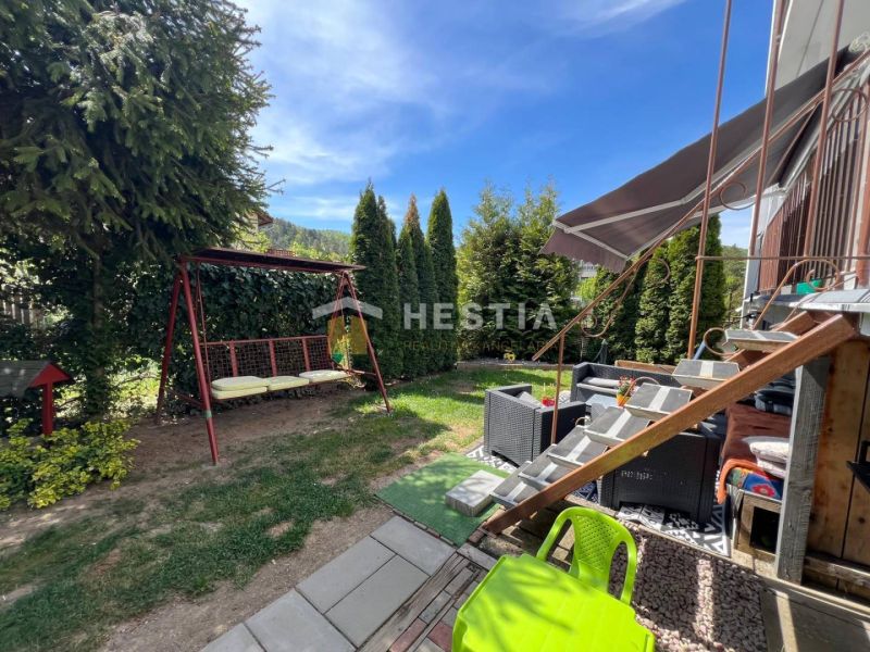 A garden with a swing and rattan seating by a 3-room apartment in Brezová pod Bradlom.
