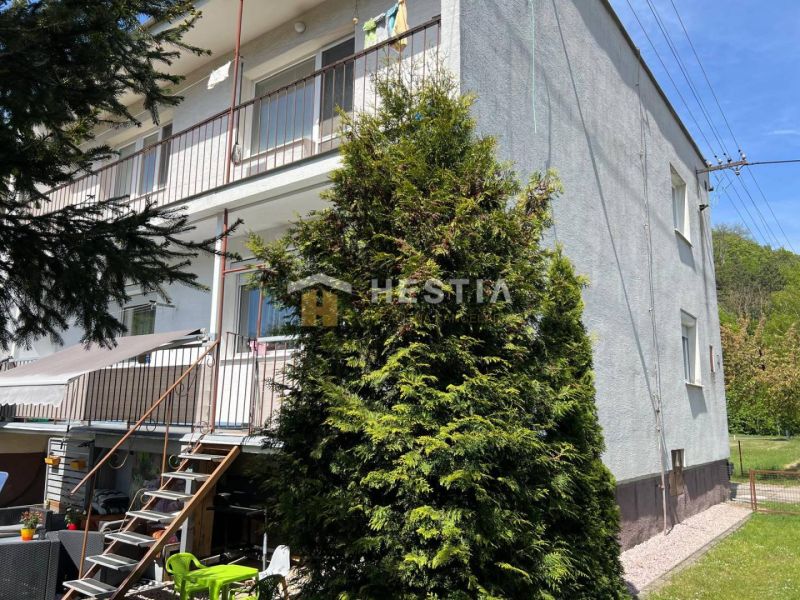Apartment building in Brezová pod Bradlom with balconies and a staircase to the garden.