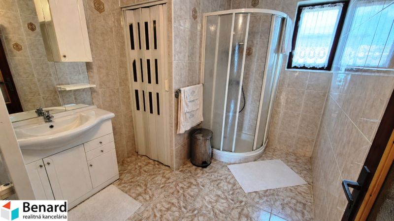A bathroom in a family house with a shower and tiles, a cozy space solution.