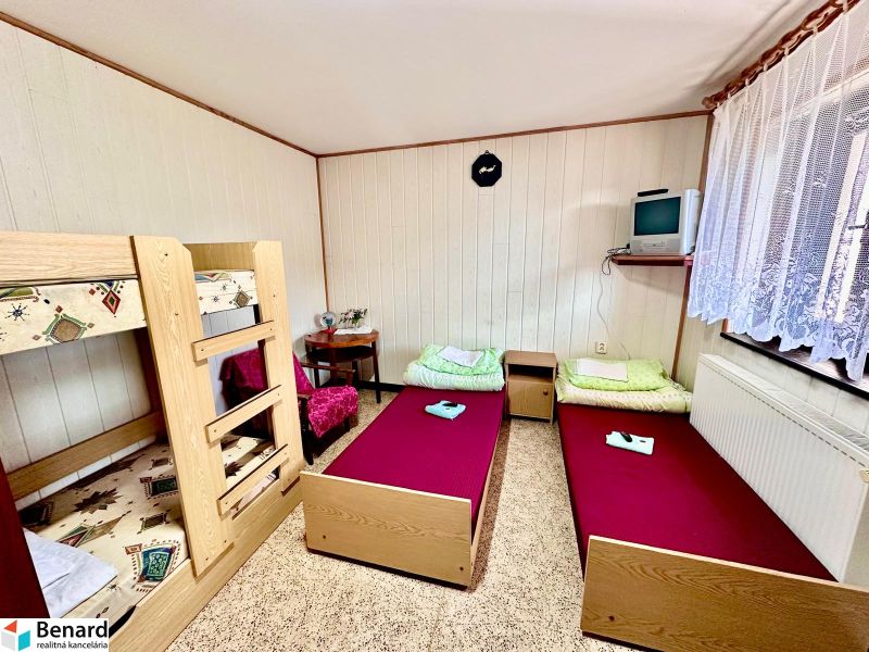 A room in a family house with a bunk bed and two single beds.