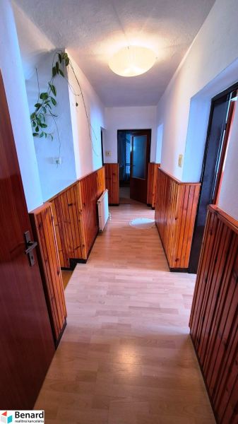 A hallway in a family house with wood-decor paneling and flooring.