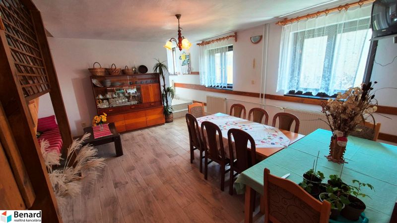 Interior of a family house with a dining table, sideboard, and wooden decor flooring.