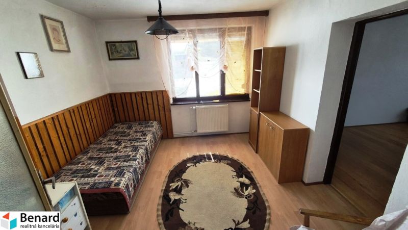A room in a family house with a bed, shelves, and a floor with a wooden decor.