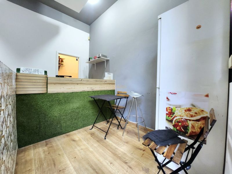 Gastro premises with a counter, stools, and a wooden decor floor.