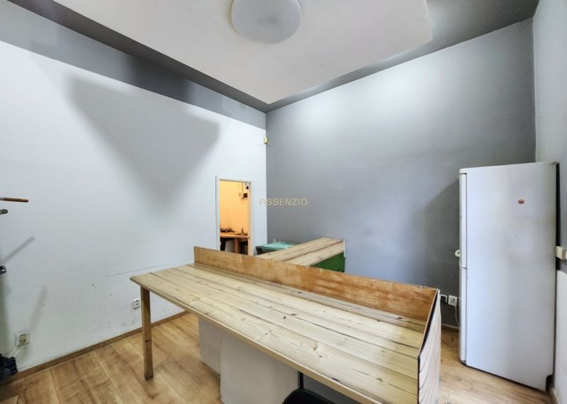 Interior of a gastro space with a wooden decor floor, table, and refrigerator.