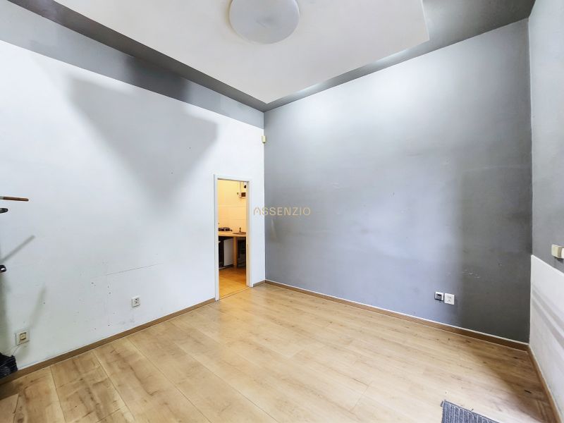 Empty interior with wood-patterned flooring and a transition to another room in the Gastro premises.