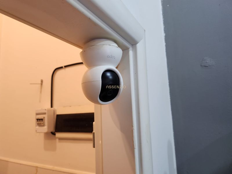 A security camera on the wall in the dining area, with electrical wiring underneath it.