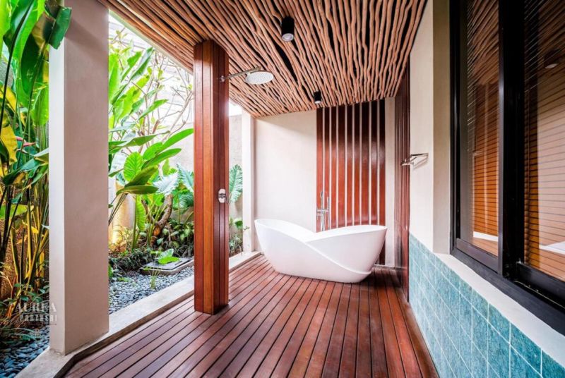 Luxurious bathroom in a villa with wooden decor and exotic plants.