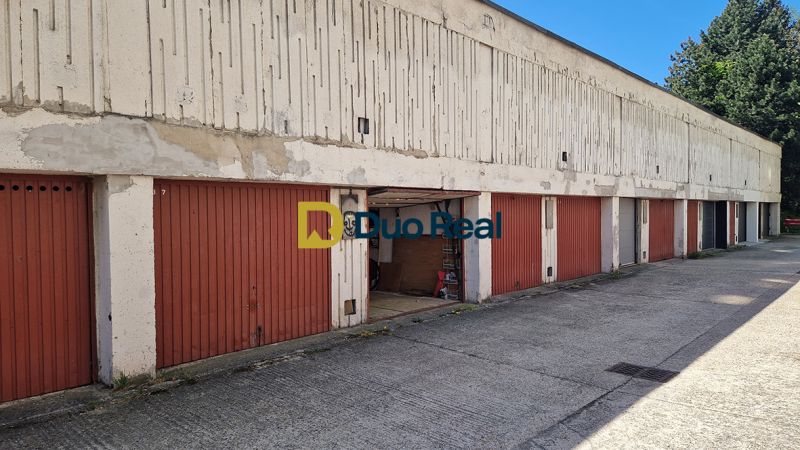 Garages on Hanulova Street in Bratislava – Dúbravka with red doors and a concrete surface.