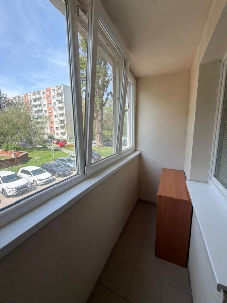 A studio apartment with a glazed loggia overlooking greenery and a parking lot in Bratislava-Petržalka.