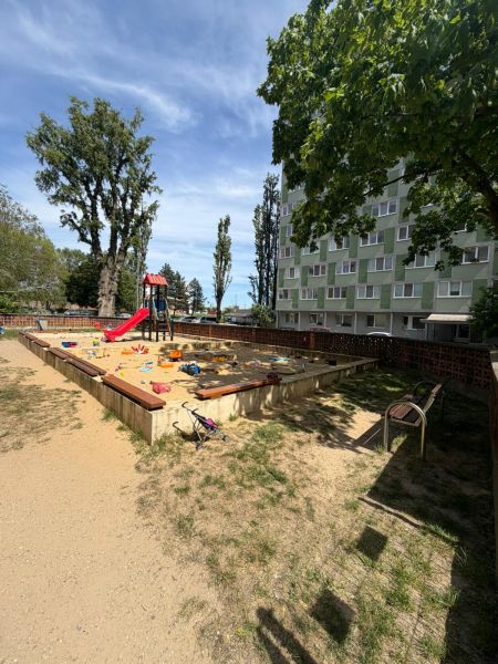 Playground in Bratislava - Petržalka with a sandbox and a slide near the apartment building.